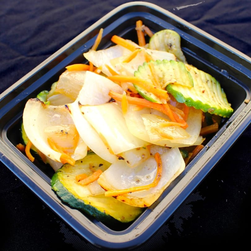 Hibachi grilled zucchini, onions, and carrots in a black takeout container from Mexihanas Hibachi Grill.